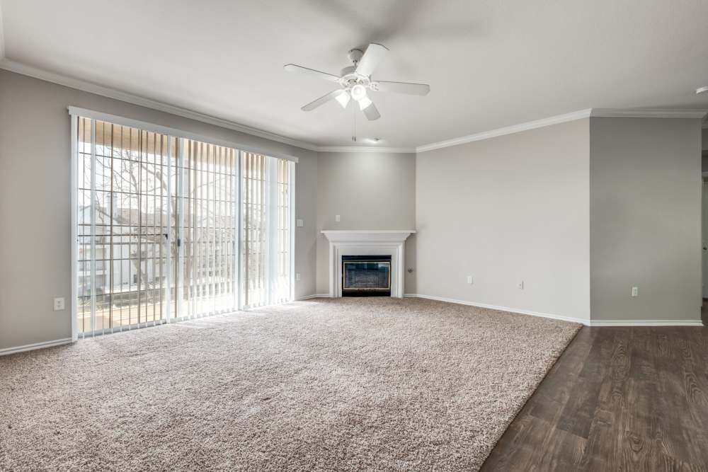 Spacious living area with plush carpet, large windows, and a cozy fireplace at Reeves and Wells in Dallas, Texas
