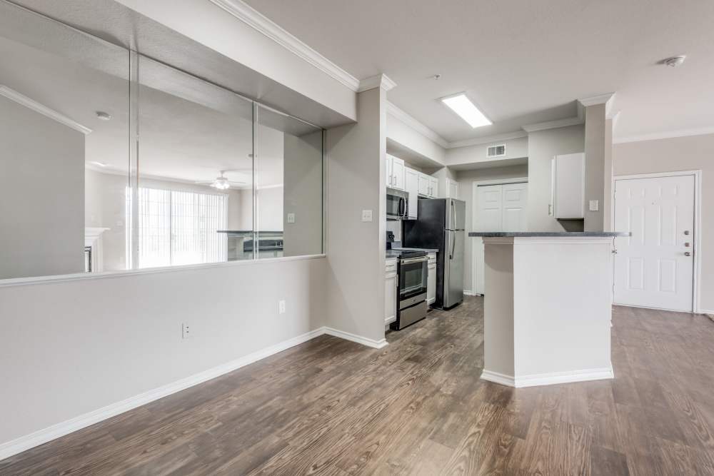 Open layout with wood-style flooring and kitchen featuring stainless steel appliances and granite countertops at Reeves and Wells in Dallas, Texas