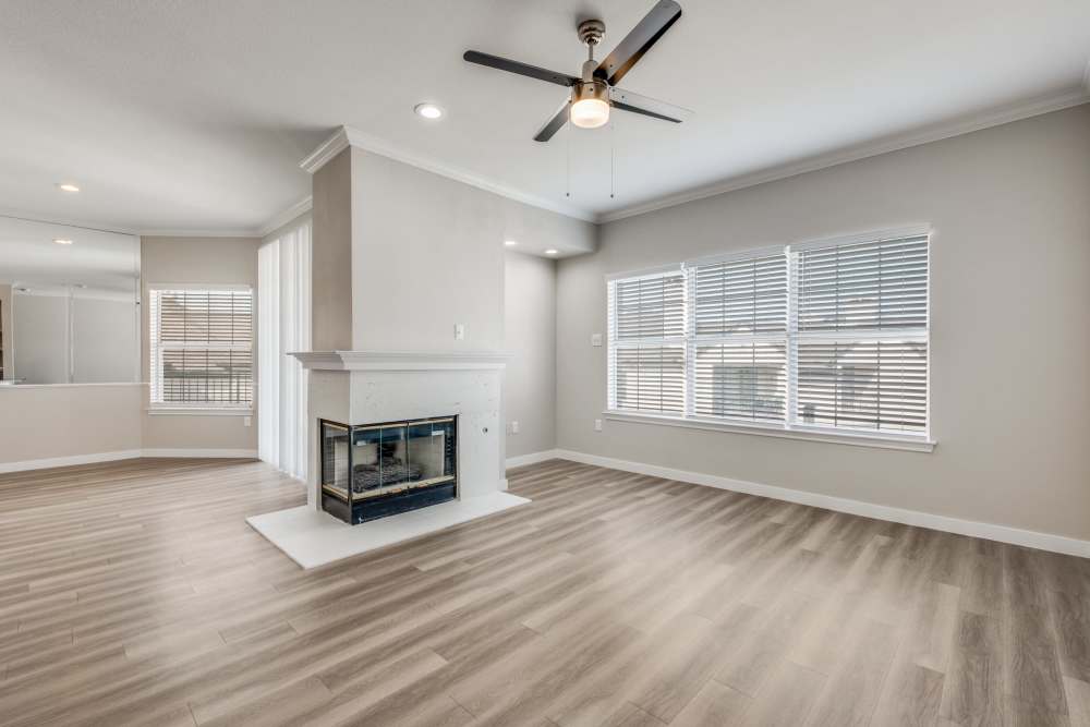 Bright living area with wood-style flooring and a cozy fireplace, large windows providing natural light at Reeves and Wells in Dallas, Texas