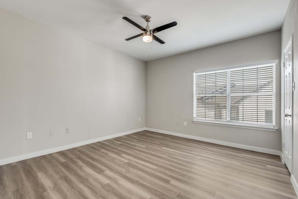 Spacious living area with wood-style flooring and large window providing natural light at Reeves and Wells in Dallas, Texas