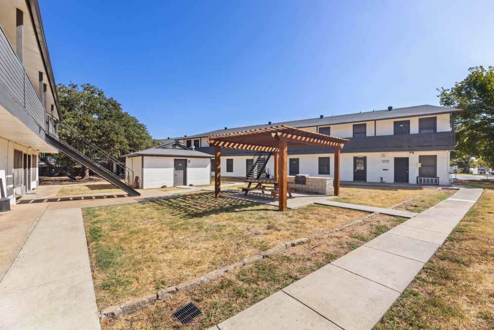 Courtyard with pergola, picnic table and grill near the leasing office at Country Oaks in Weatherford, Texas