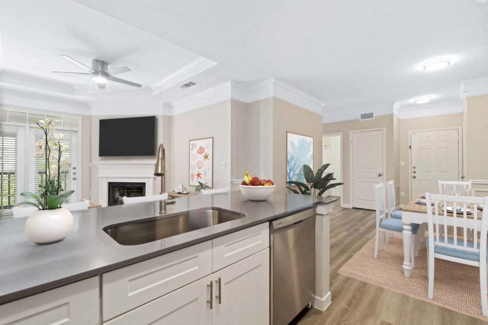 Open layout kitchen with stainless steel appliances, granite countertops, and wood-style flooring at Reeves and Wells in Dallas, Texas