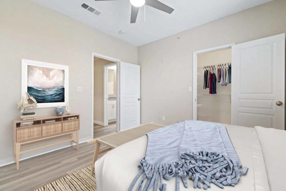 Cozy bedroom with wood-style flooring, stylish artwork, and a spacious closet entrance at Reeves and Wells in Dallas, Texas