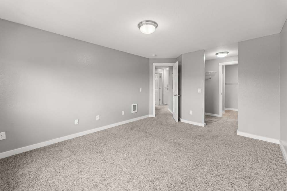 Carpeted room with ceiling light and hallway access at Fieldstone in Fairview, Oregon.