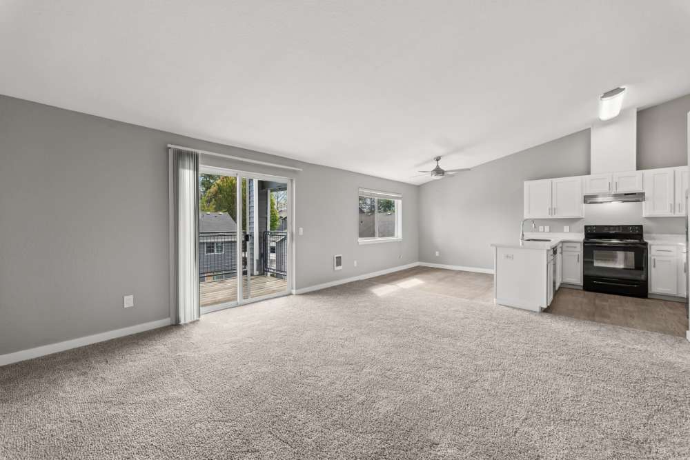 Living room with sliding glass door and open kitchen at Fieldstone in Fairview, Oregon.
