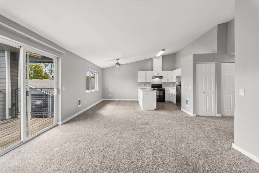 Living room with sliding door and view of kitchen at Fieldstone in Fairview, Oregon.