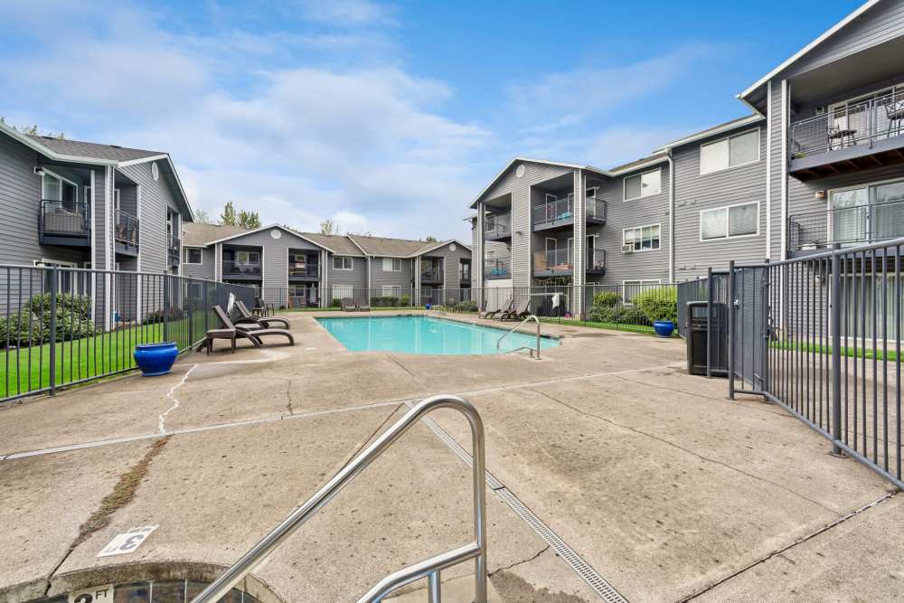 Fenced swimming pool deck beside apartment buildings at Fieldstone in Fairview, Oregon.
