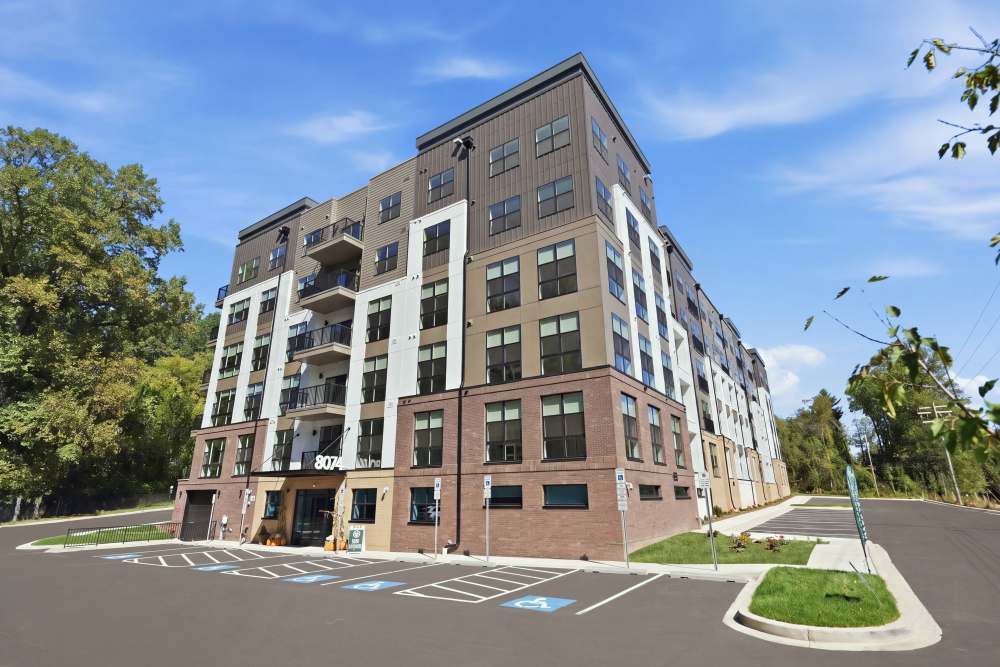 Apartment exterior view with lawn and car parking at The Residences at Patapsco in Ellicott City, Maryland