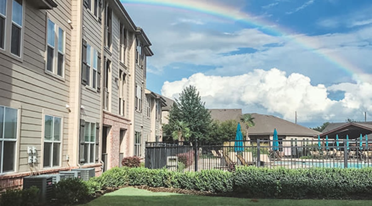 Beautiful apartment grounds with a rainbow in the background at Le Rivage Luxury Apartments in Bossier City, Louisiana