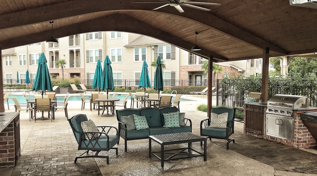 Covered poolside patio with barbeque at Le Rivage Luxury Apartments in Bossier City, Louisiana