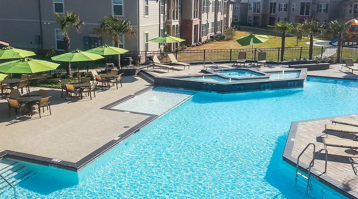 Cheerful sun umbrellas poolside at Le Rivage Luxury Apartments in Bossier City, Louisiana