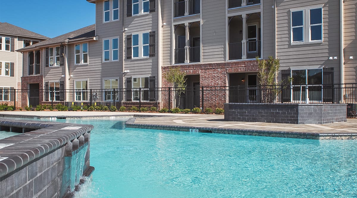 Beautiful resort-style pool surrounded by apartments at Le Rivage Luxury Apartments in Bossier City, Louisiana
