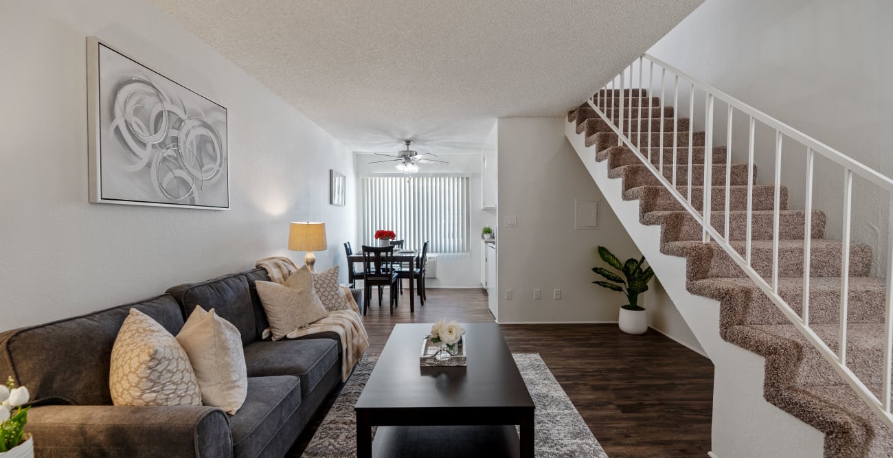 Spacious and bright townhome style apartment living room with an open concept dining and a staircase to access the bedroom at Vista Pointe II in Studio City, California