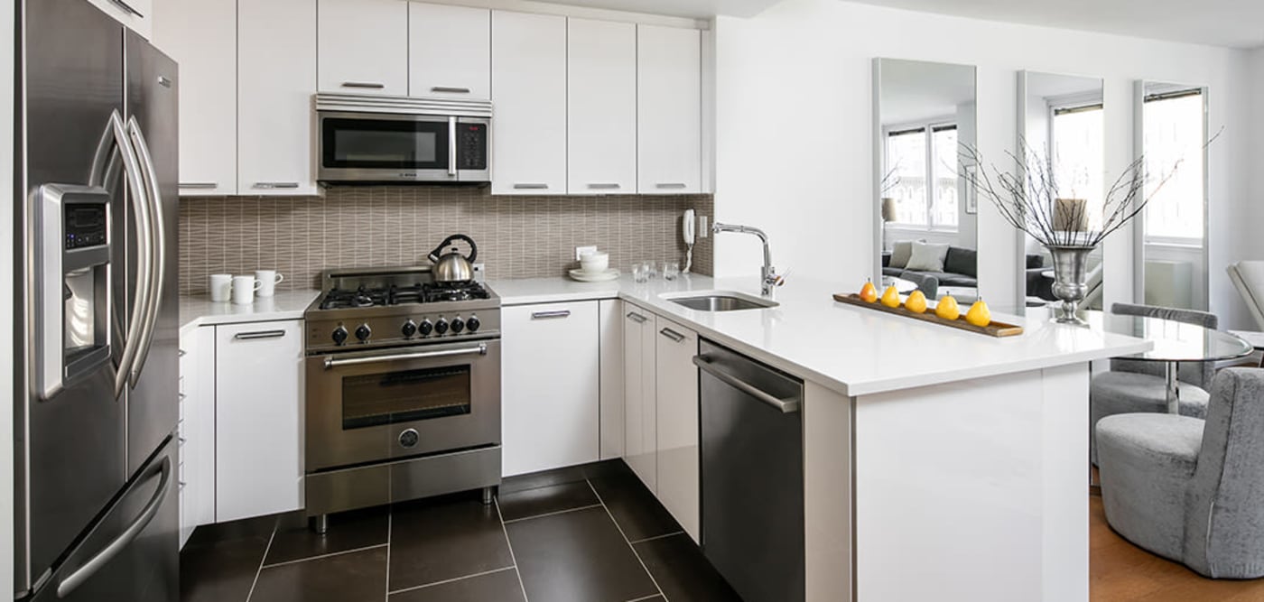 Large kitchen with breakfast bar and stainless steel appliances at The Melar in New York, New York