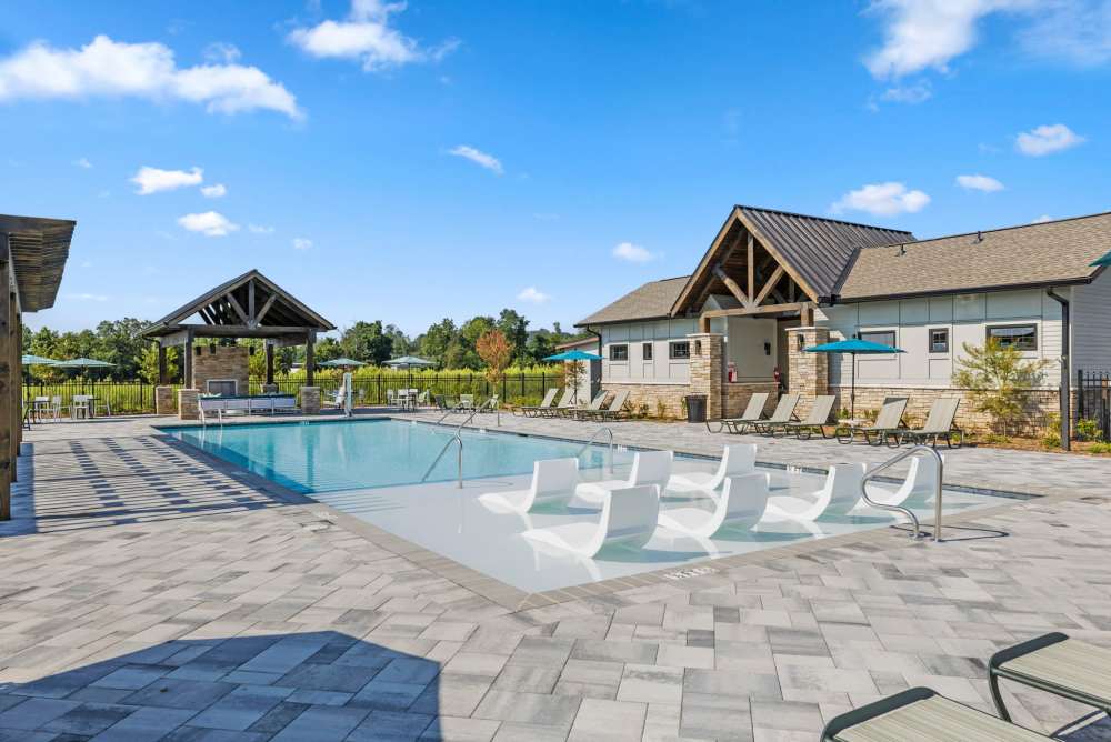 Resort-style pool with shaded lounge areas and pavilion seating at Artisan Living Mills River in Mills River, North Carolina