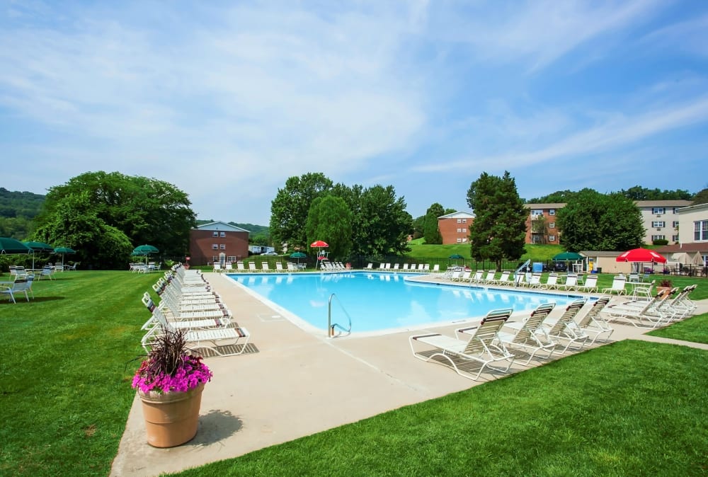 Swimming pool surrounded by lounge chairs at Kingswood Apartments & Townhomes in King of Prussia, Pennsylvania
