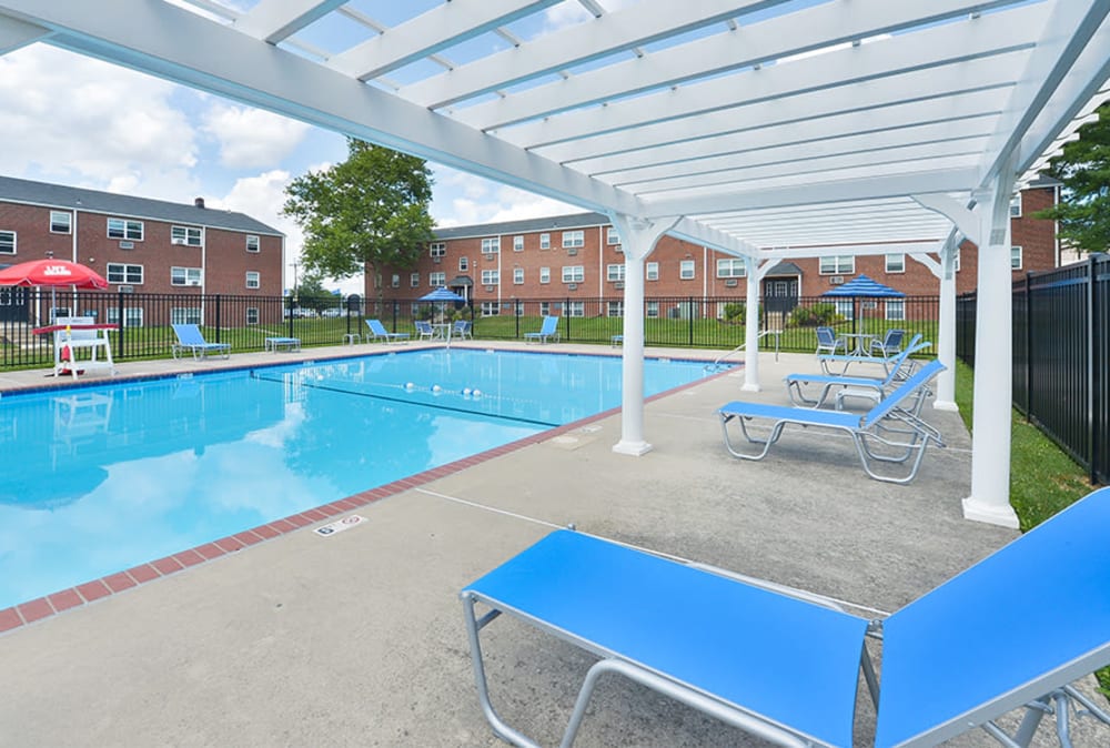 Lounge seating by the sparkling swimming pool at Hyde Park Apartment Homes in Bellmawr, New Jersey