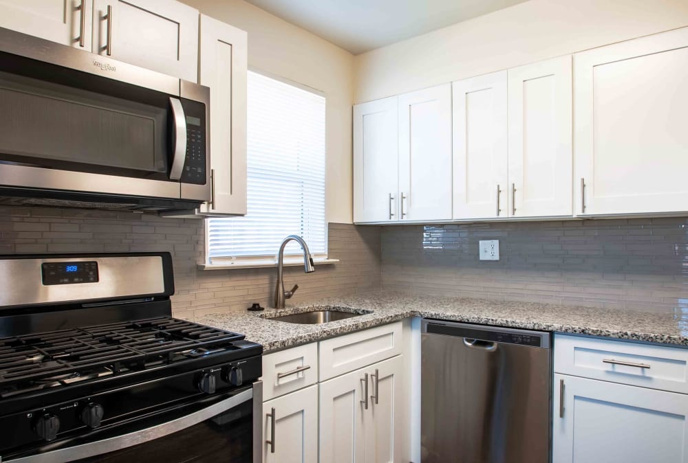 Upgraded kitchen with white cabinets and stainless appliances at Camp Hill Plaza Apartment Homes in Camp Hill, Pennsylvania