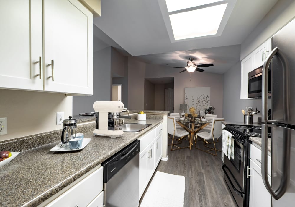White Renovation Kitchen with Stainless steel appliances at Sierra Del Oro Apartments in Corona,CA