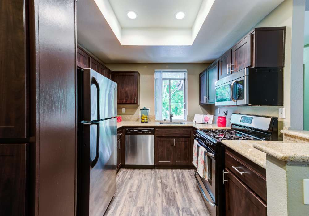  Modern kitchen with wooden cabinets and stainless-steel appliances at Seapointe Villas in Costa Mesa, California