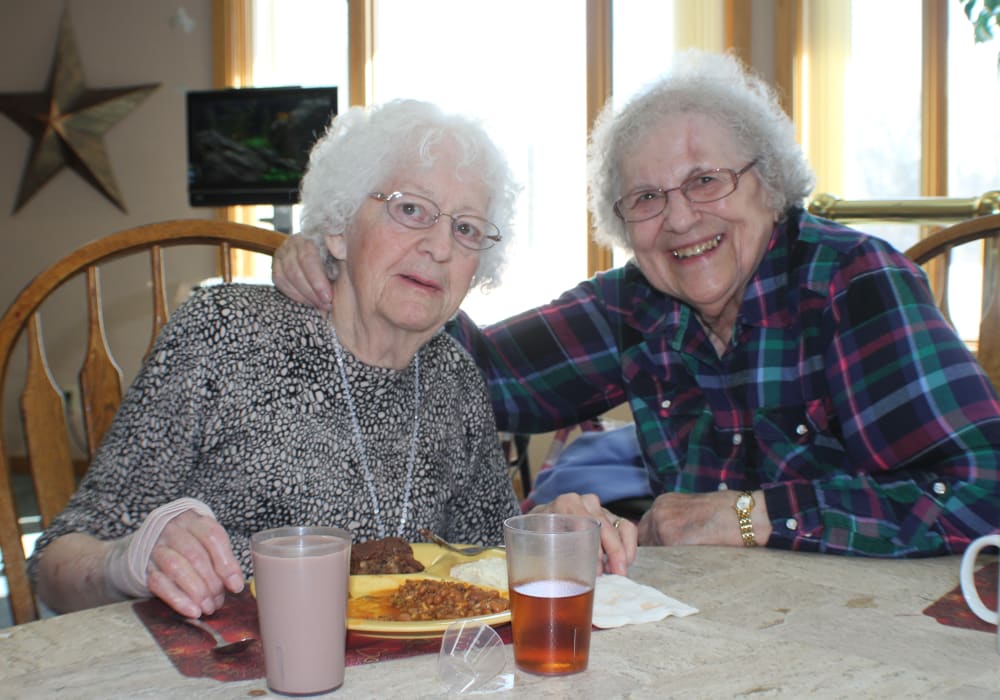 Residents smiling for a photo and dining at Wellington Meadows in Fort Atkinson, Wisconsin