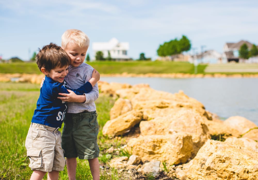 Kids hugging by lake at BB Living Harvest in Argyle, Texas