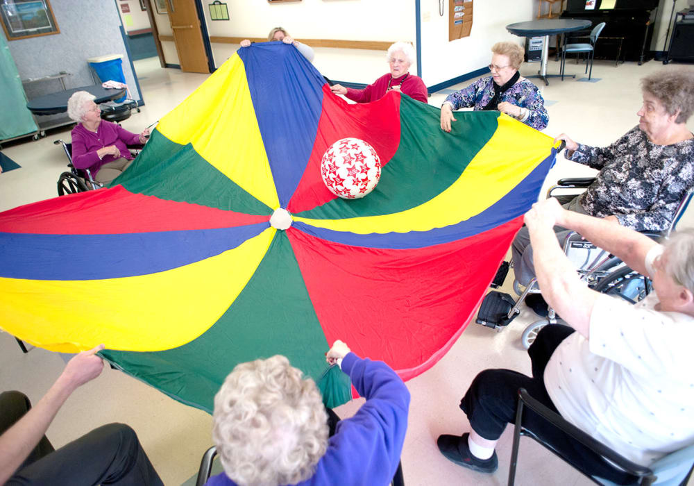 Group of residence playing with a parachute and ball at Ingleside Communities in Mount Horeb, Wisconsin