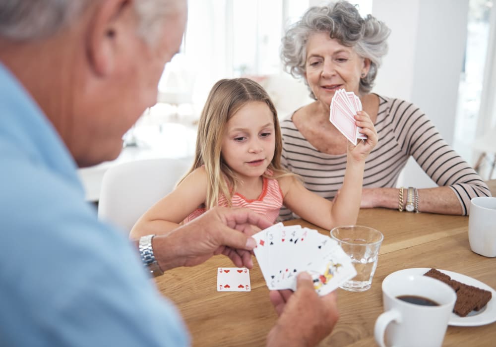 Residents playing cards with a little girl at Village on the Park Onion Creek in Austin, Texas