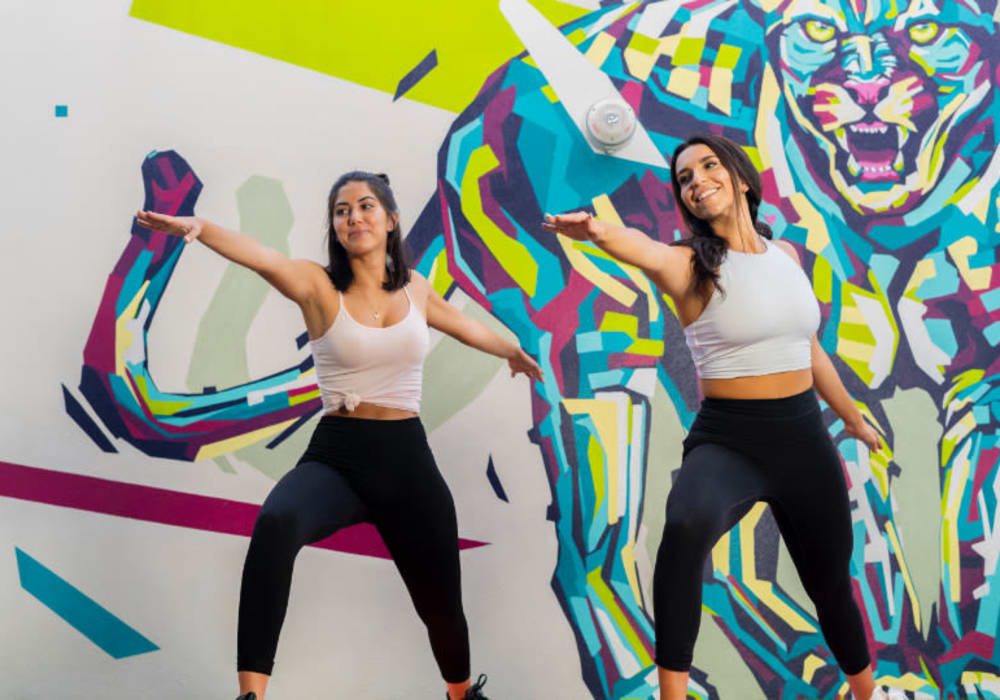 Residents doing yoga in front of a mural at Motif in Fort Lauderdale, Florida