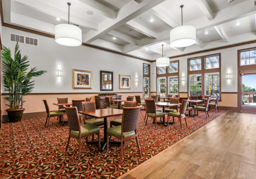 Dining tables and seating in the community dining room at Mariposa at Clear Creek in Webster, Texas