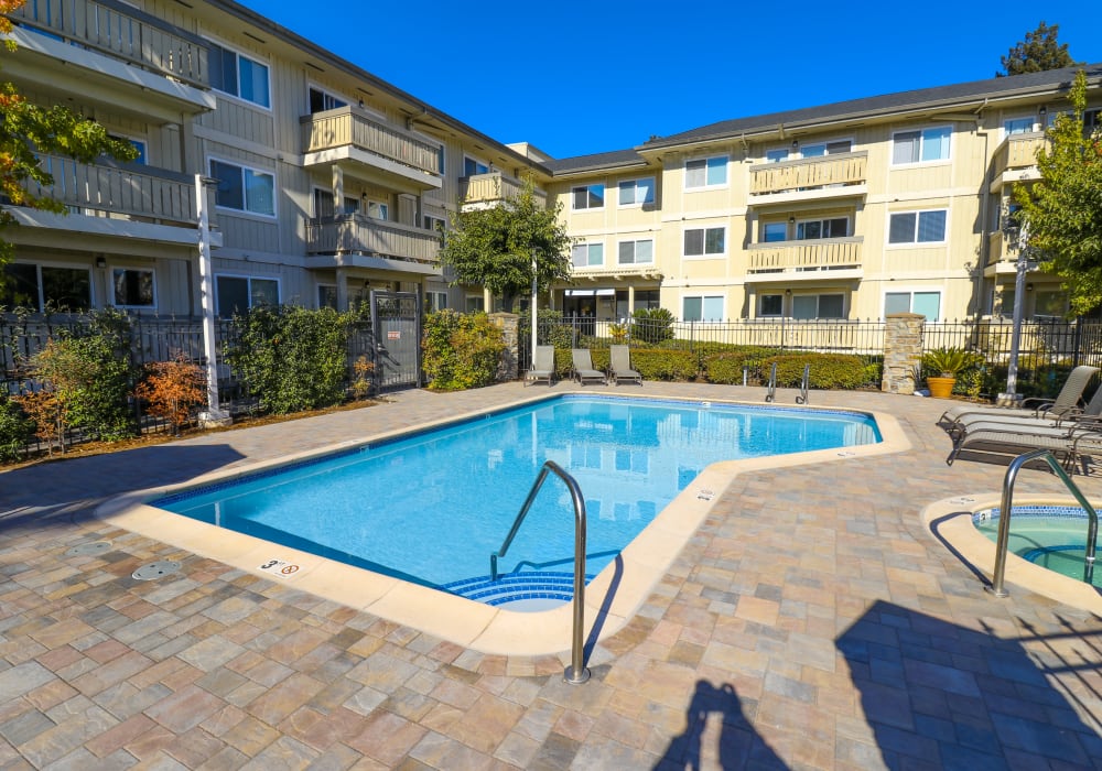 Swimming pool and sauna with an expansive sundeck at Summerhill Terrace Apartments in San Leandro, California