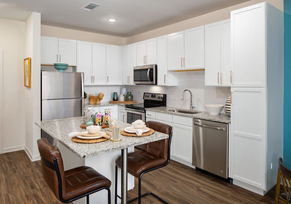 Eat-in apartment kitchen with white cabinets at The Iris at Northpointe in Lutz, Florida