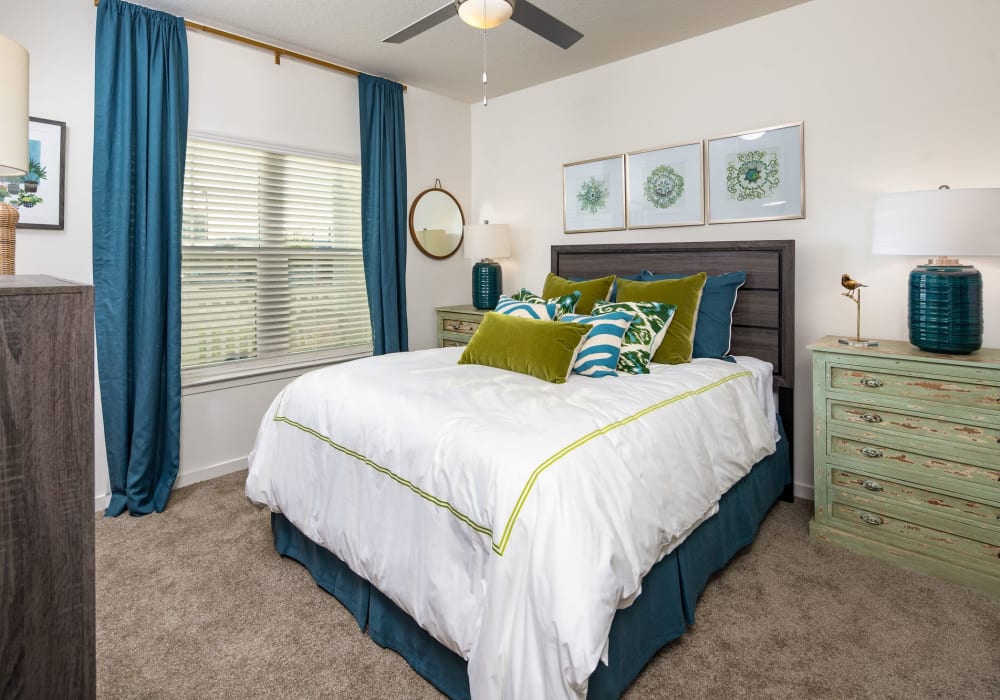 Carpeted apartment bedroom with queen-size bed at The Iris at Northpointe in Lutz, Florida