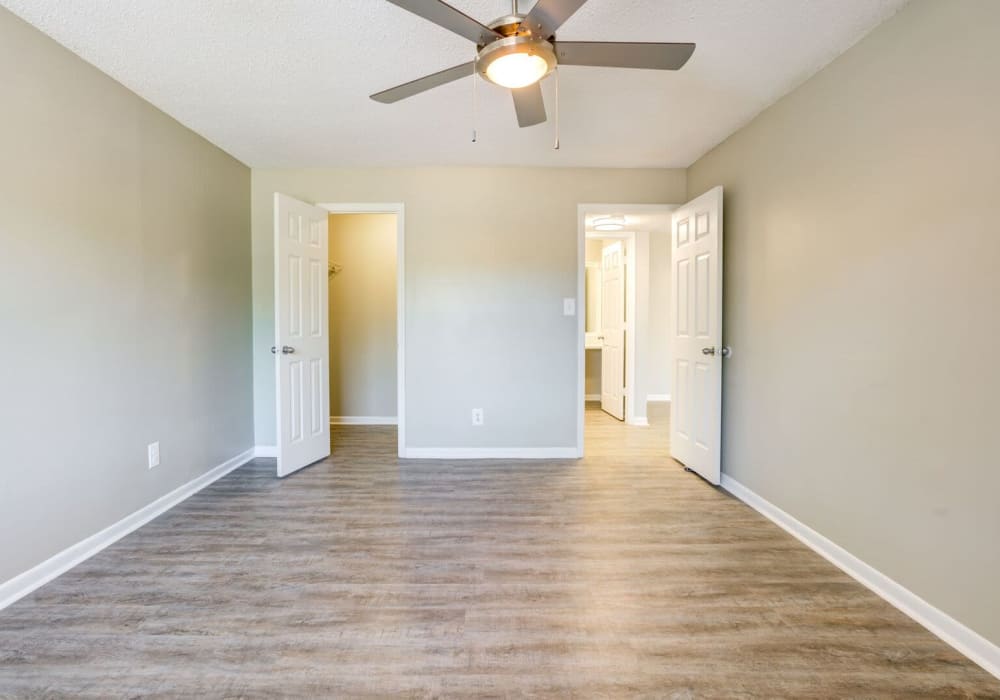 Apartment bedroom with closet, ceiling fan, and hardwood floors at Stone Creek in Tampa, Florida