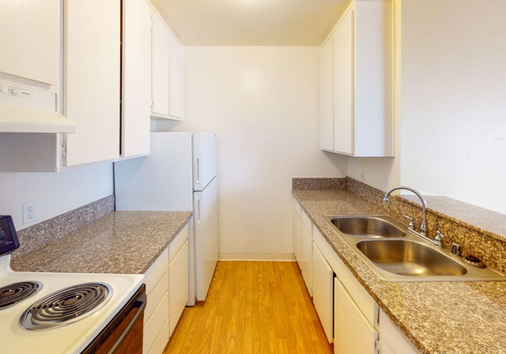 Model kitchen with hardwood floors at Alpine Terrace Apartments in Canoga Park, California