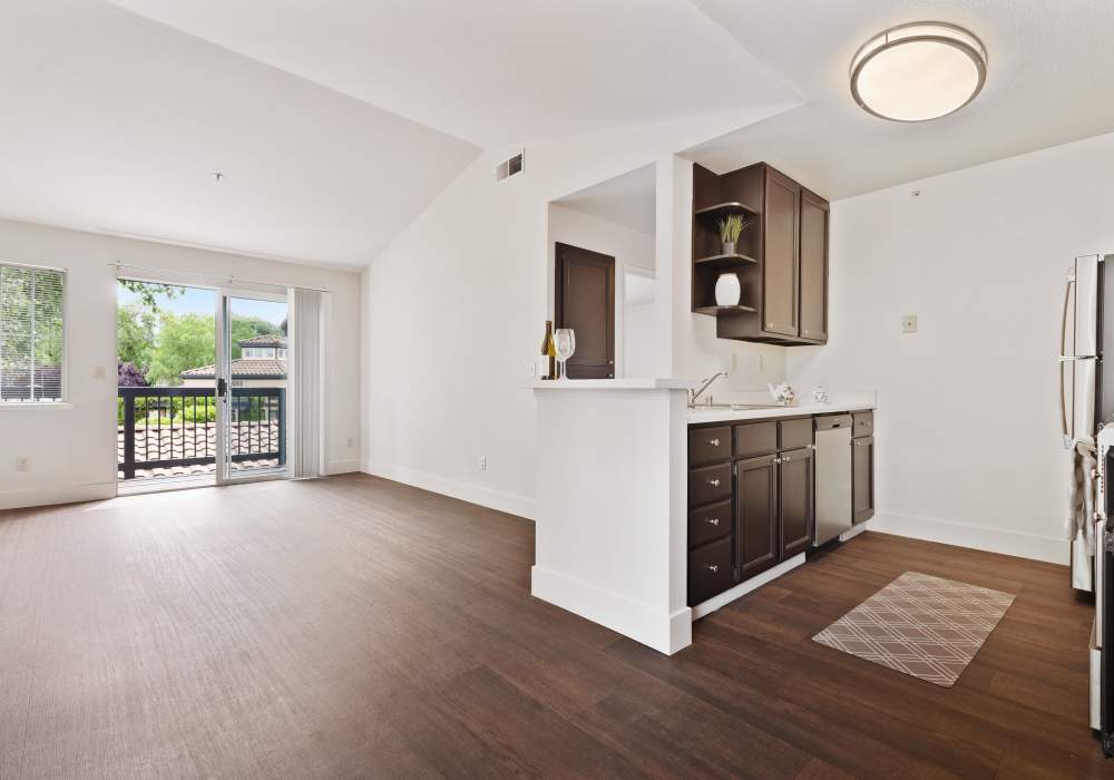 View of the kitchen and a door leading to the private balcony at La Vina Apartments in Livermore, California