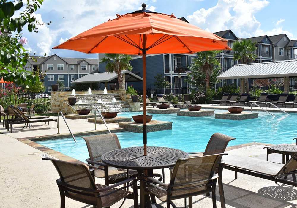 Umbrella covered table by the swimming pool at Oak Forest in Victoria, Texas