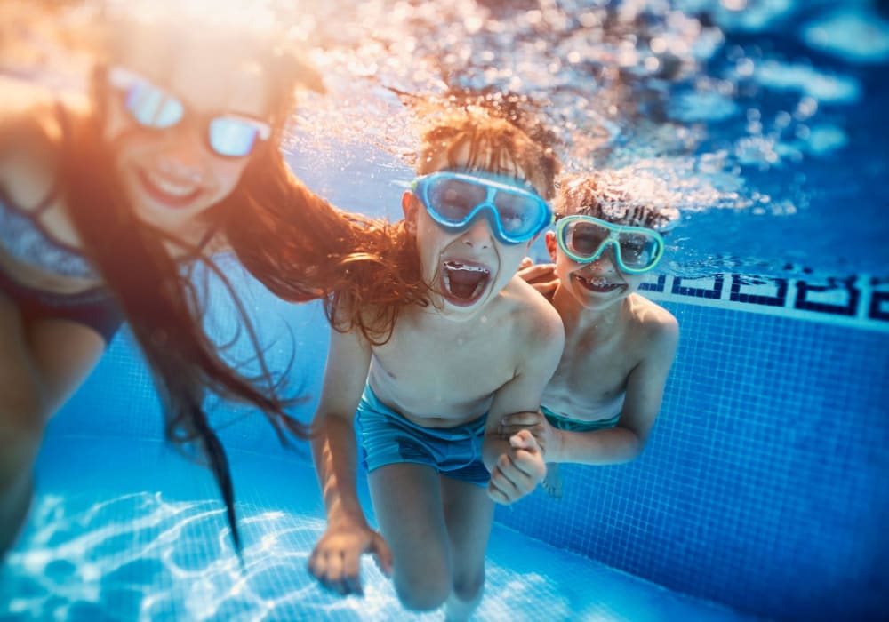 3 children under water with goggles at El Macero Apartments in Davis, California