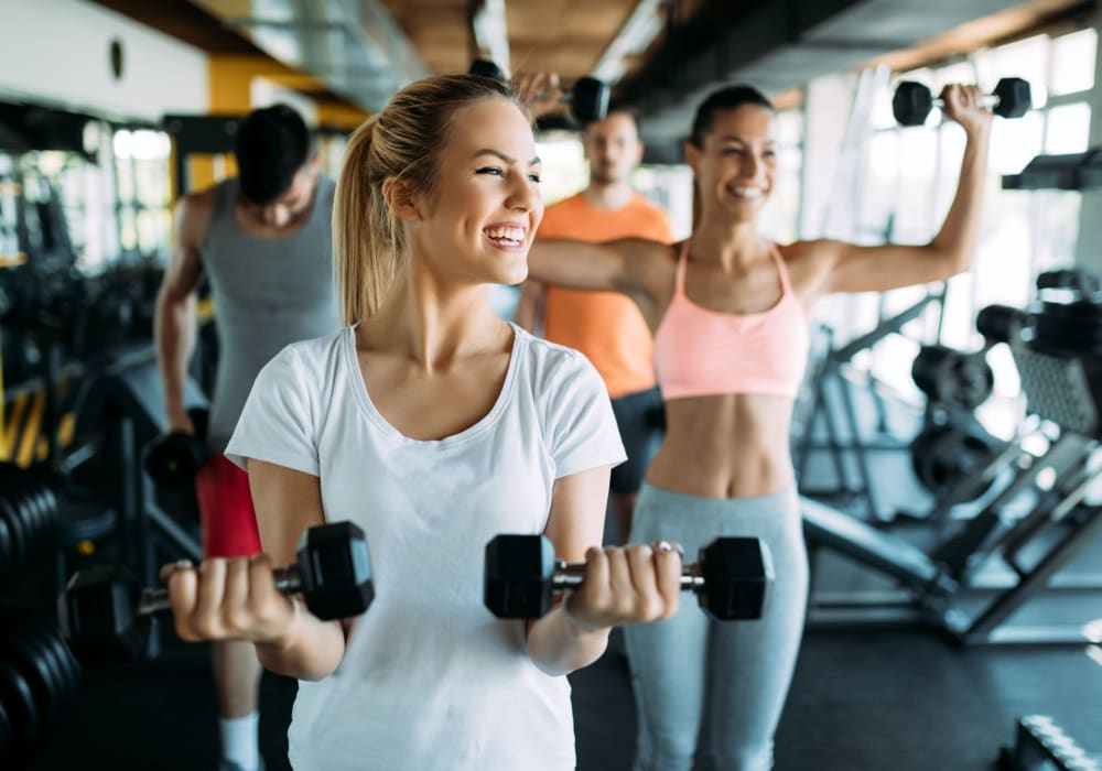 Happy residents lifting wights at gym at El Macero Apartments in Davis, California