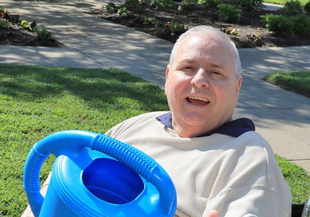 Happy resident watering garden at O'Fallon in O'Fallon, Missouri