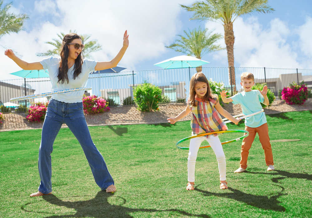 Mom and kids playing with hula hoops on the lawn at BB Living Wellen Park in Venice, Florida