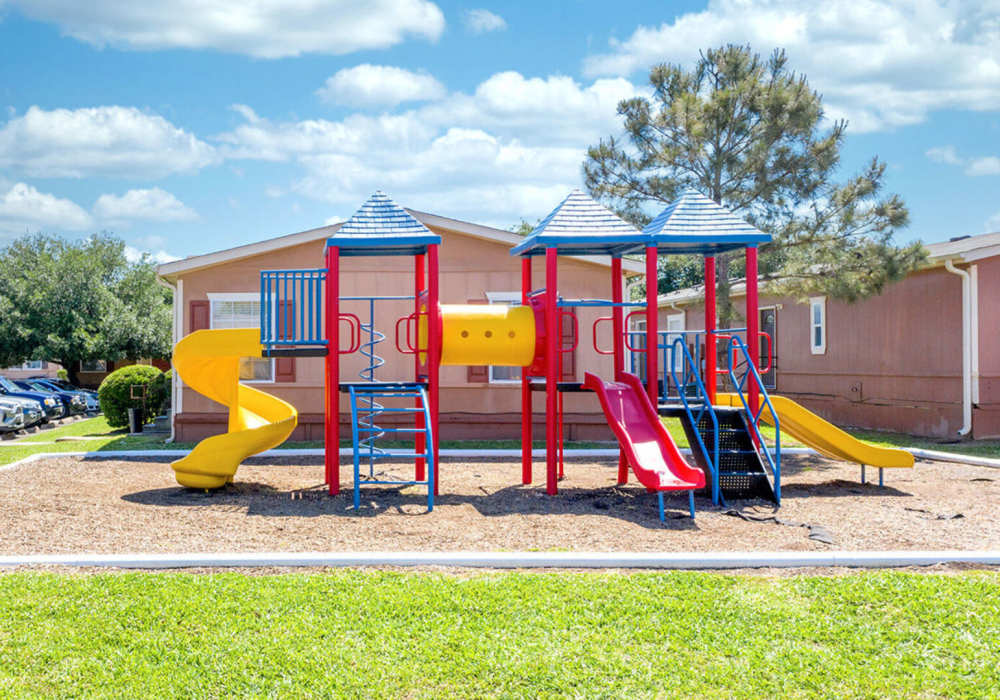 Playground area with two sliders at Waterstone Place Apartments in Stafford, Texas