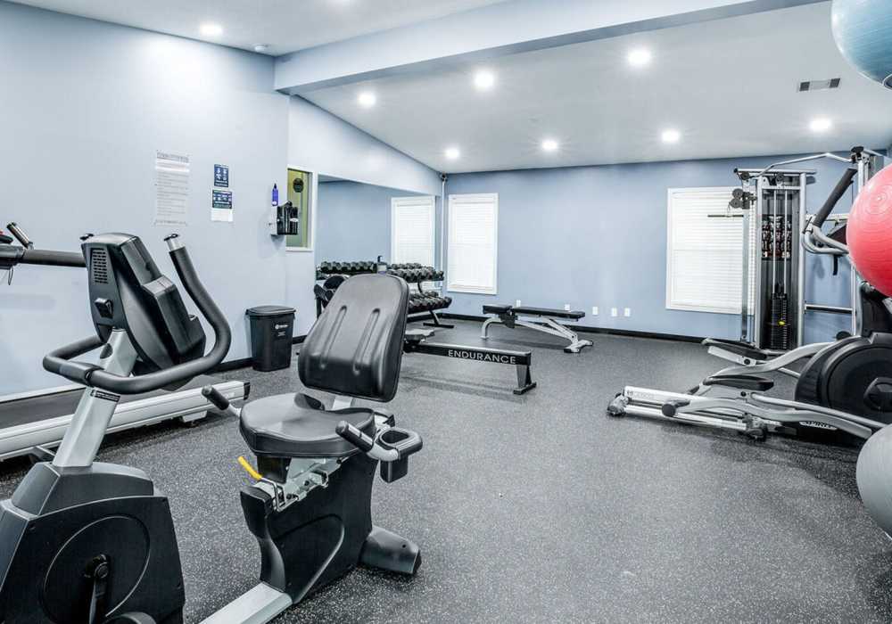 Gym with fitness equipment at Waterstone Place Apartments in Stafford, Texas 