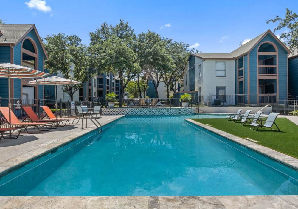 Resort style swimming pool with lounge chairs at Hill At Woodway in San Antonio, Texas
