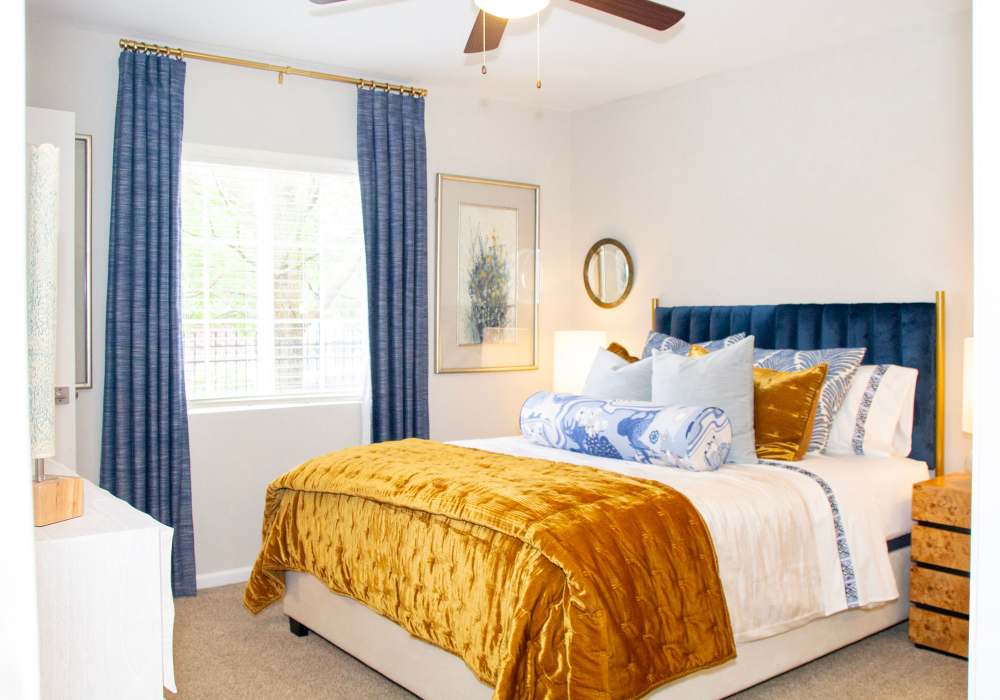 Well-lit bedroom with large window and ceiling fan at Battleground North in Greensboro, North Carolina