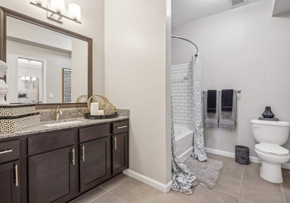 Bright and spacious bathroom with curved shower bar and stylish finishes at The Cascades in Antioch, Tennessee