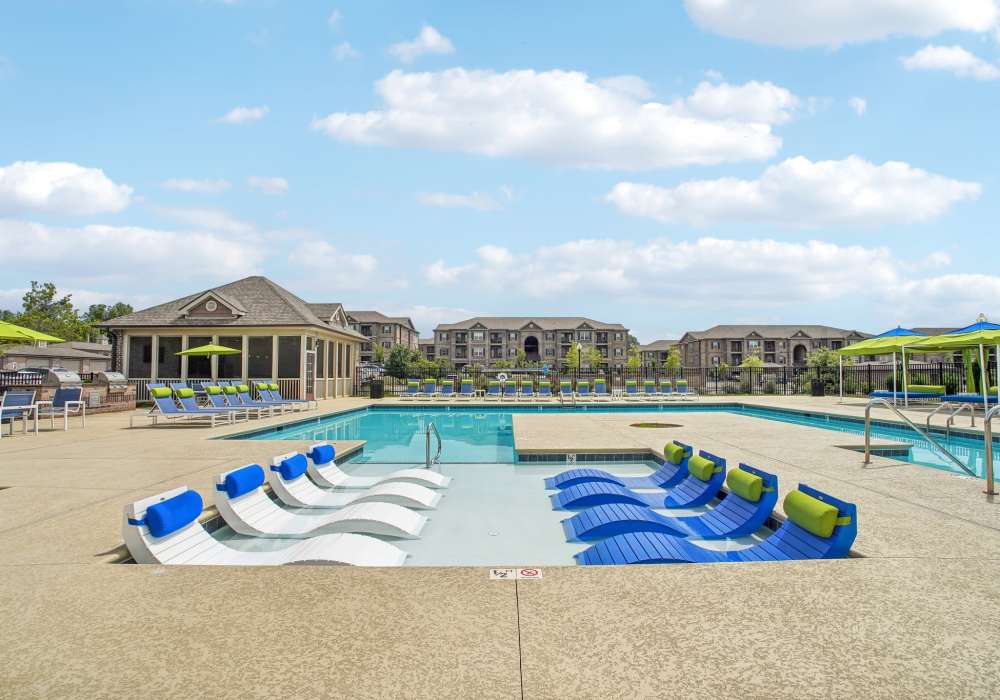 Sparking resort-style pool with chaise lounge in the pool's sun ledge at The Cascades in Antioch, Tennessee