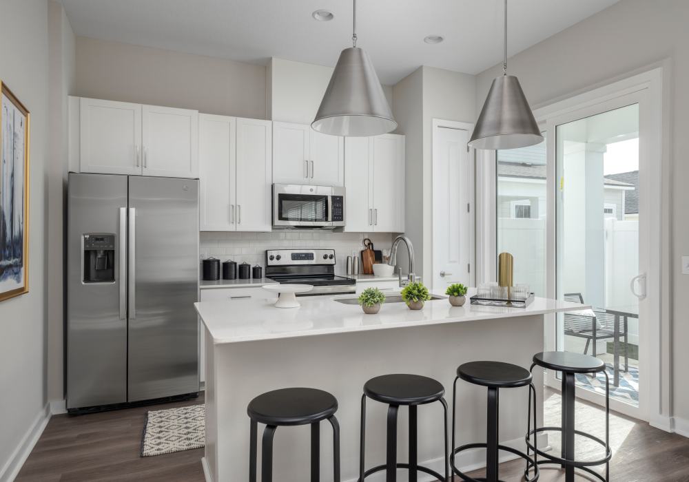 Kitchen with bar seating in a model home at Cottage Street at eTown in Jacksonville, Florida