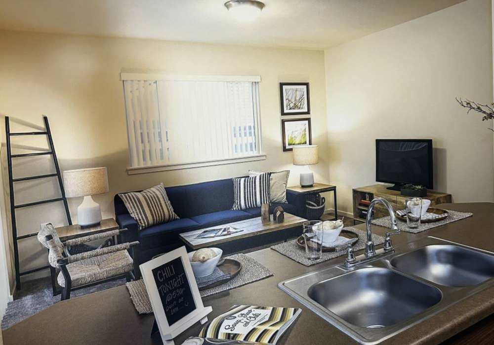 Open layout of kitchen and living room with countertop bar at Copper Wood in Lacey, Washington