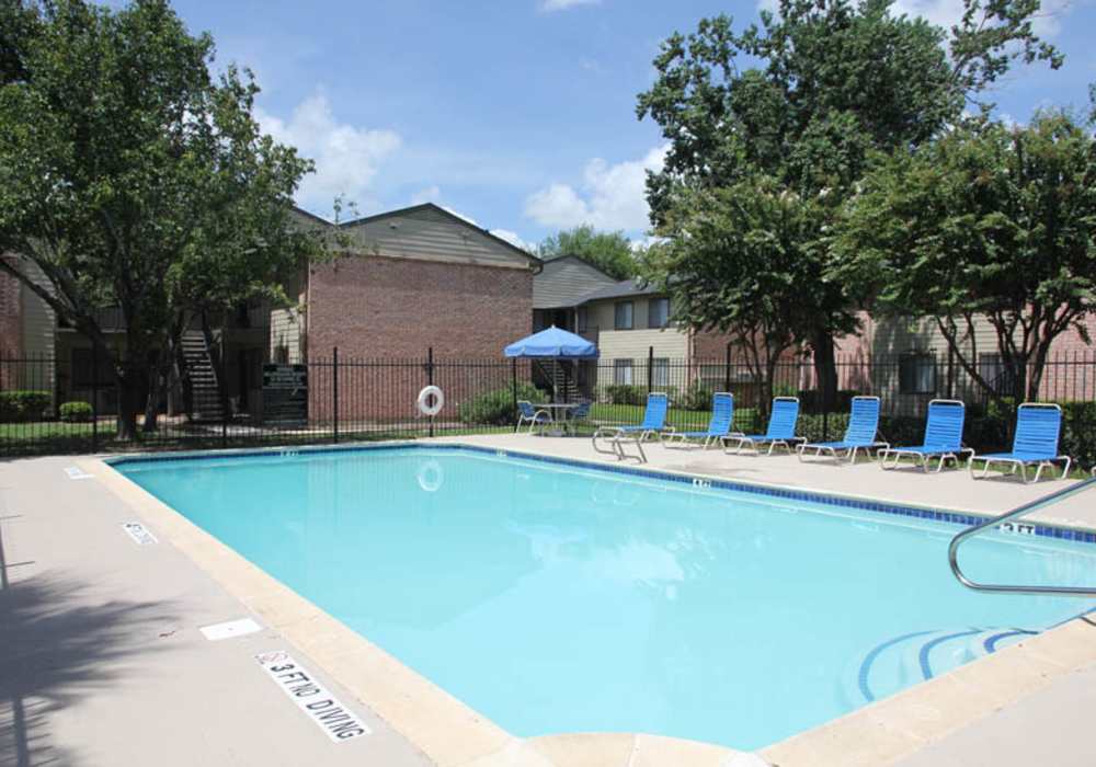 A large swimming pool with greenery surrounded at Park Place in Pearland, Texas